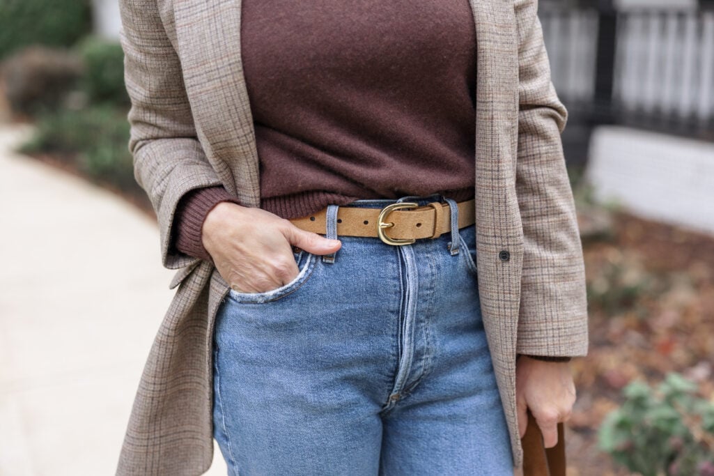 Detail shot of tan suede belt at waist with heather espresso cashmere sweater and plaid blazer showing proportions for petites