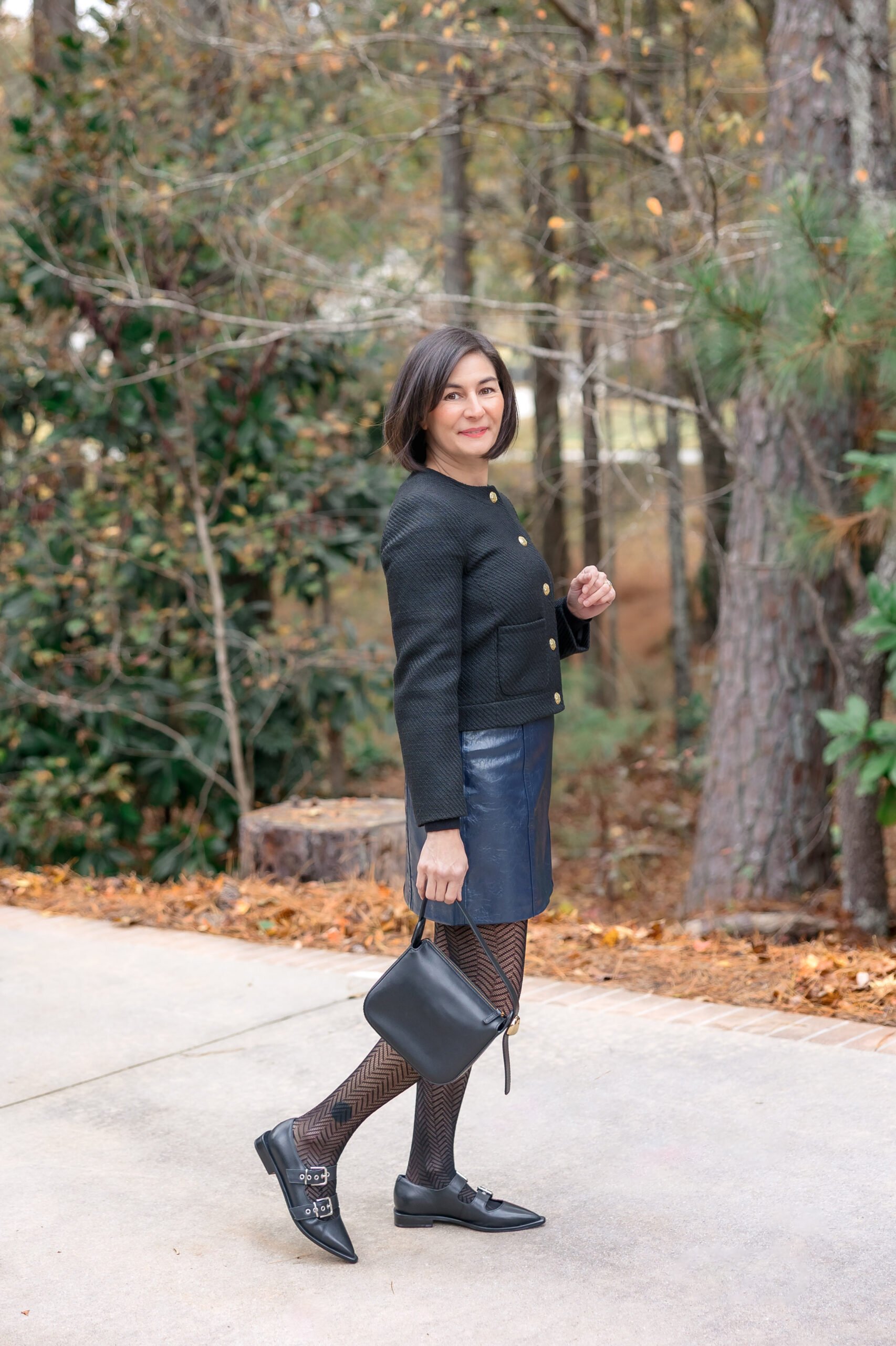 Kelly wearing a faux leather mini skit with chevron tights, a tweed lady jacket, and Mary Jane flats