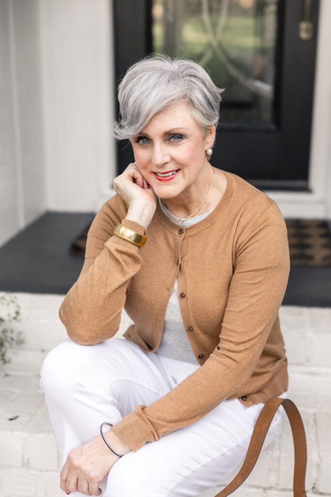 woman over 50 camel cardigan red lipstick classic makeup and timeless style