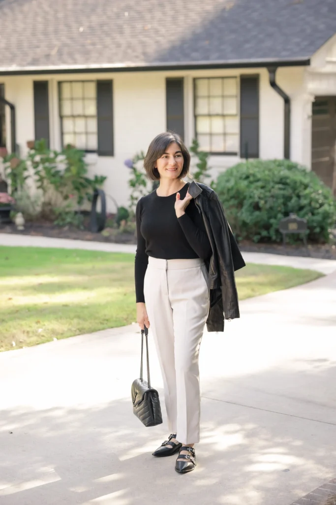 Kelly wears a cashmere sweater and slim white trousers from Quince