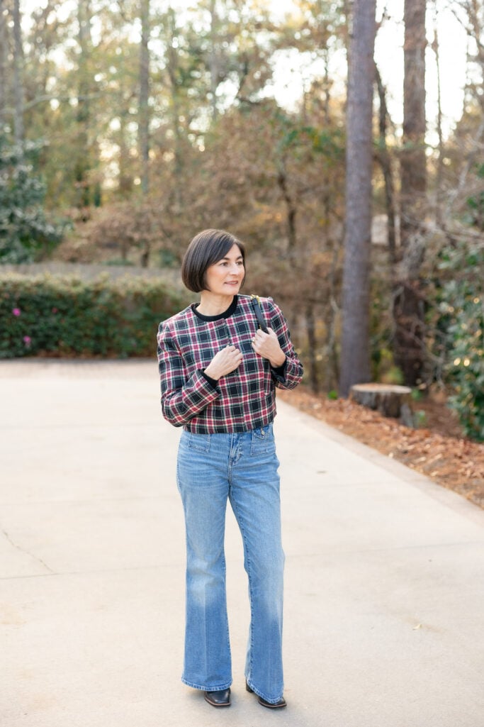 Full length view of Kelly in Stewart tartan plaid jacket, black cashmere sweater and vintage flare jeans showing casual holiday party outfit proportions for petites