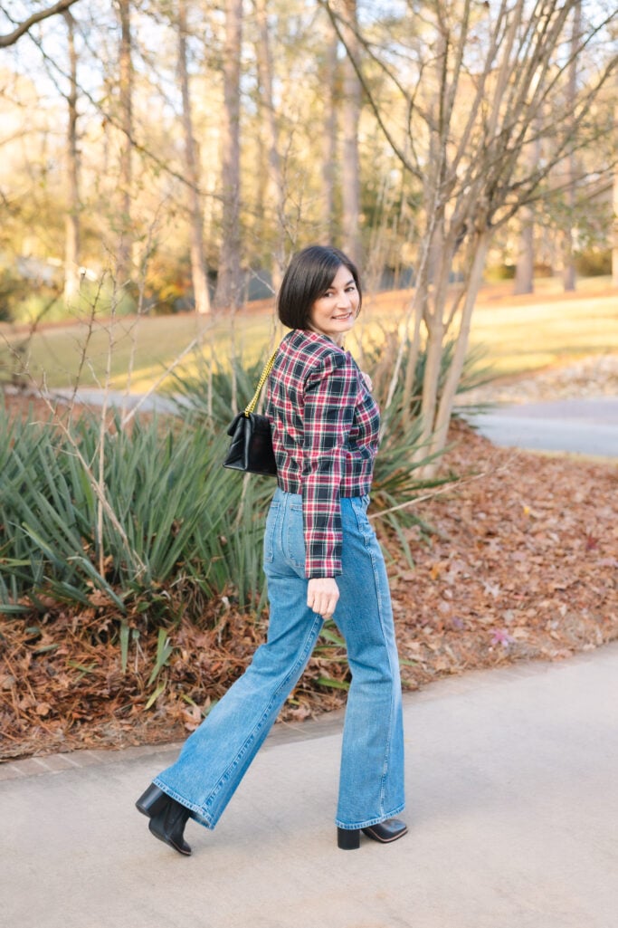 Back view of Kelly in Stewart tartan jacket with vintage flare jeans and mid-calf boots showing petite casual holiday party outfit proportions from behind