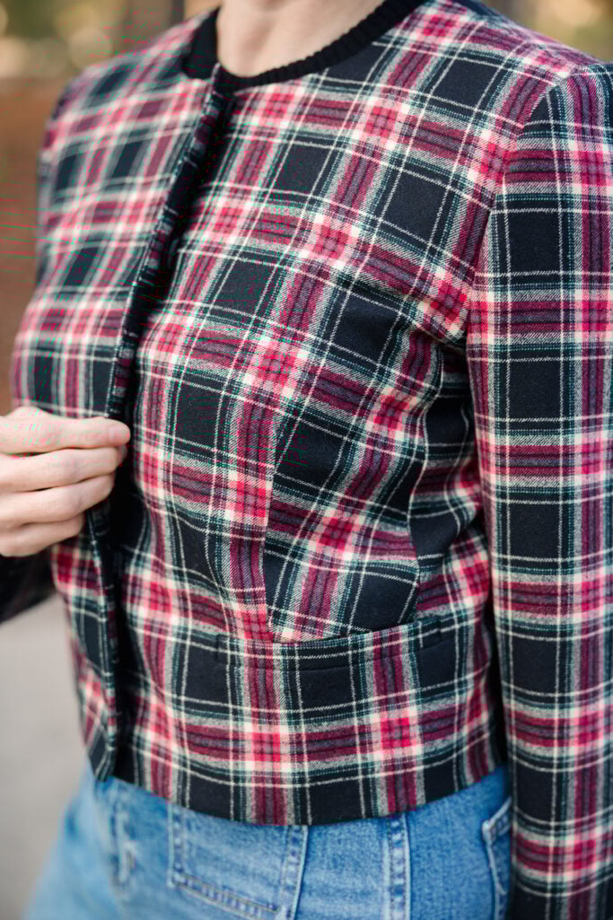 Close-up detail of Stewart tartan plaid jacket fabric showing red, green, white and black holiday pattern