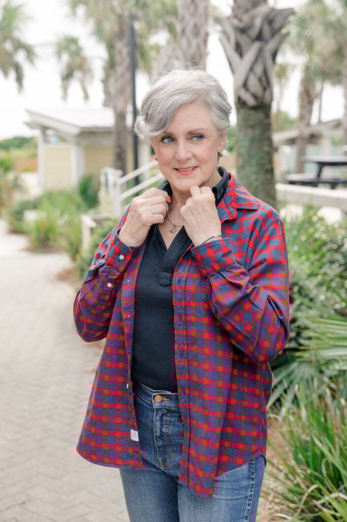 Woman over 50 with silver hair wears a plaid flannel shirt from Frank & Eileen with jeans and a tee shirt