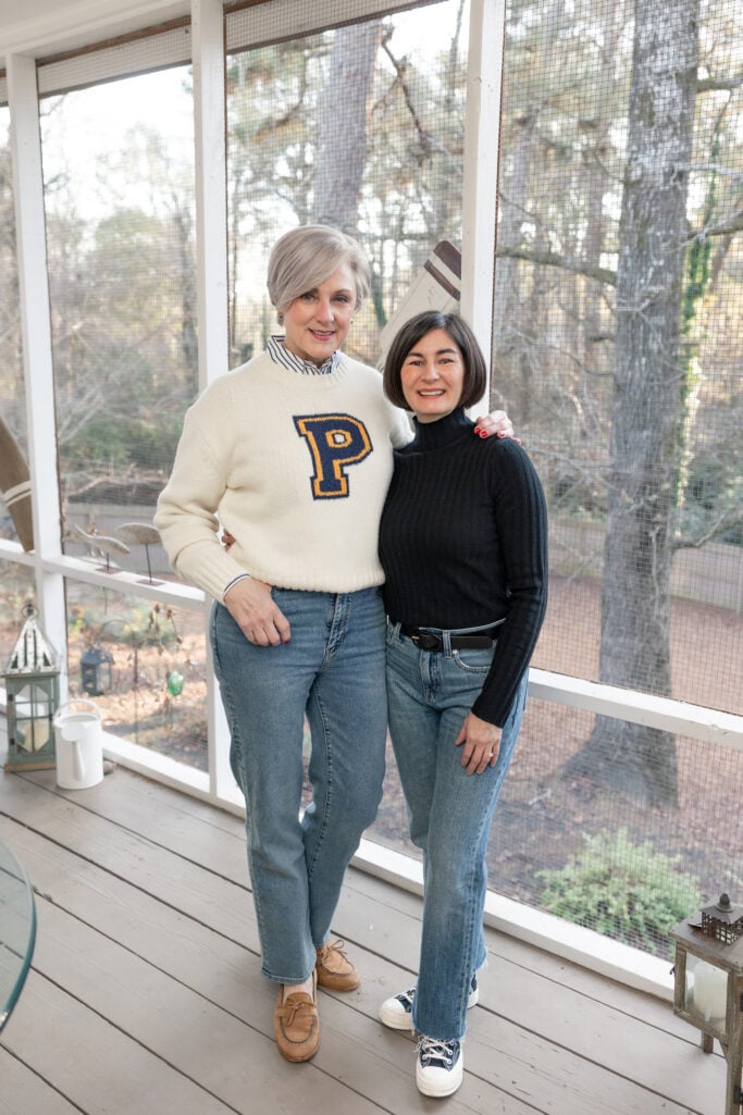 Full-length view of Beth and Kelly together on the porch, showing both complete outfits with their coordinating jeans and comfortable footwear