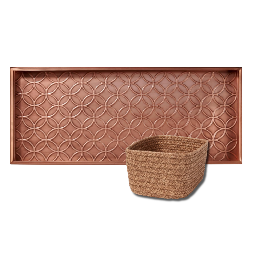 Small rectangular woven storage basket made from natural fibers, ideal for organizing blankets, books, or everyday household items arranged in front of a copper-toned boot tray with embossed geometric pattern.