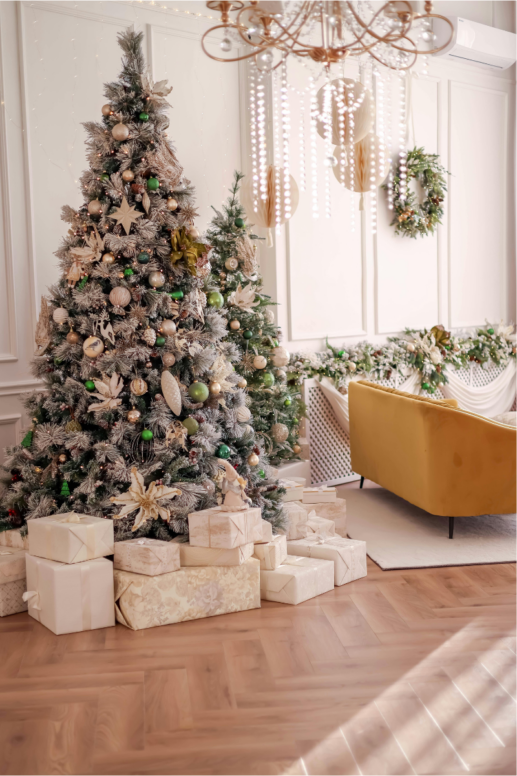 Elegant living room decorated for the holidays with a flocked Christmas tree adorned in neutral and green ornaments, wrapped gifts beneath, soft garlands, and warm lighting creating a cozy, festive atmosphere.