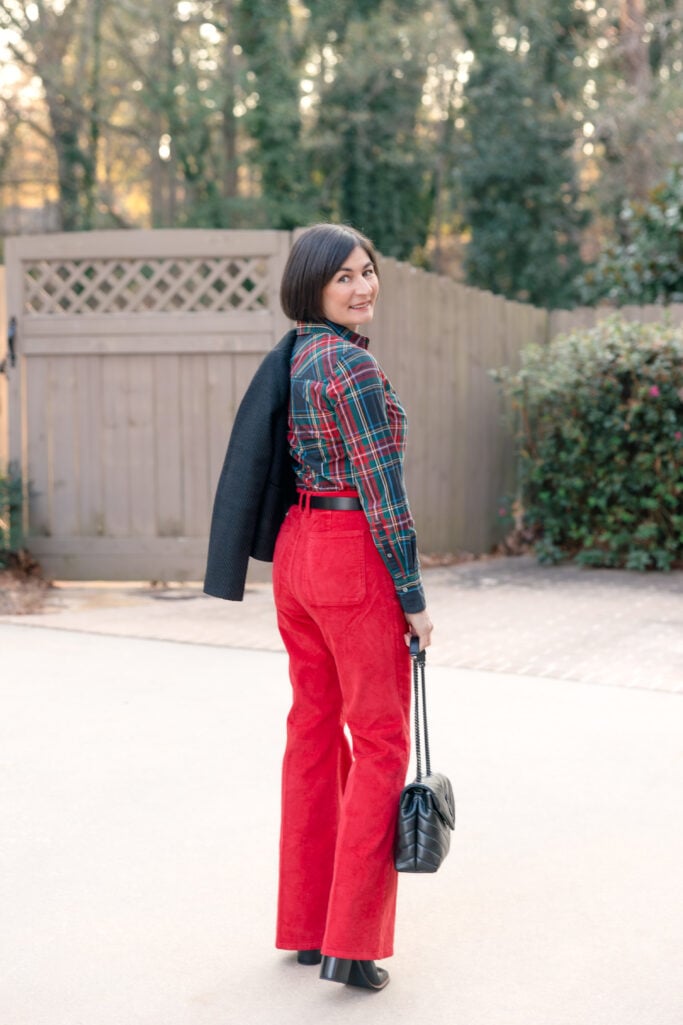 Back view of Kelly in red corduroy pants and black tweed jacket showing petite proportions and jacket length for holiday outfit