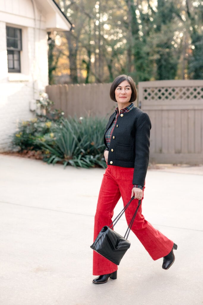 Kelly walking in red J.Crew corduroy pants with plaid shirt and tweed jacket showing movement and fit of wide-leg flare pants for petites