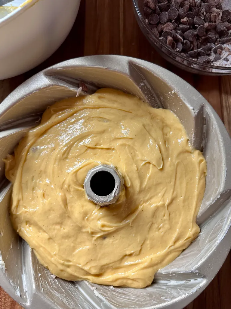 Second layer of yellow cake batter smoothed over streusel in bundt pan