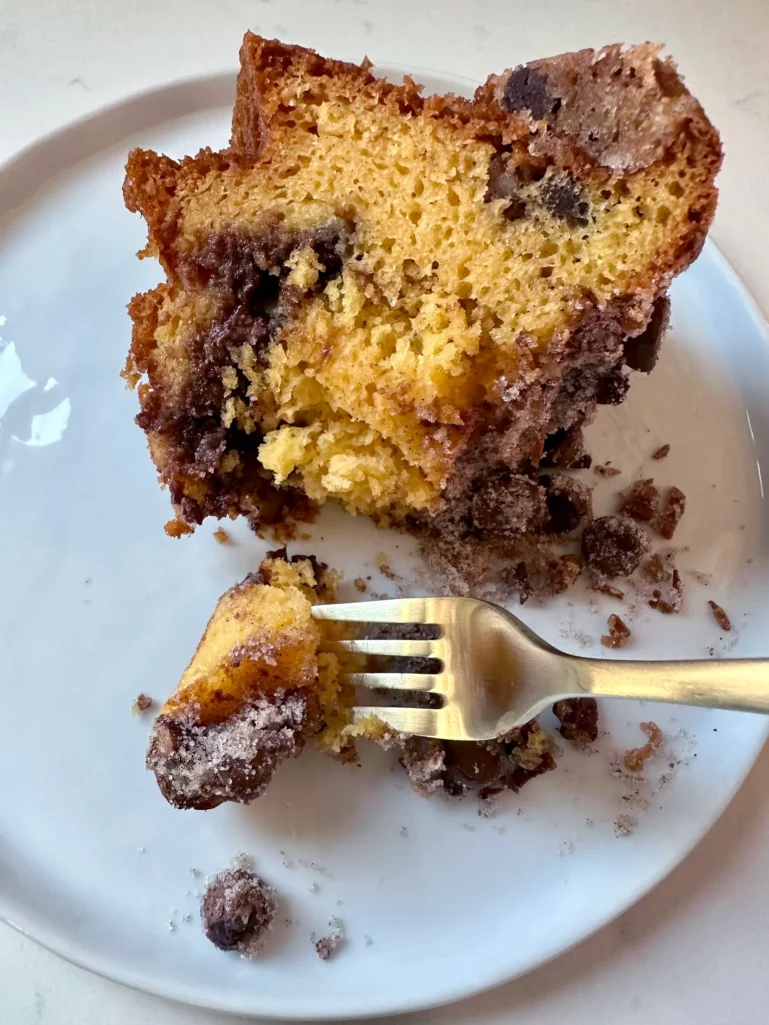 Slice of moist chocolate cinnamon coffee cake showing streusel layers with a fork
