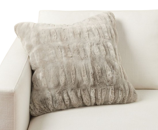 Pottery Barn faux fur ruched pillow cover in a soft neutral taupe tone, styled on a light upholstered sofa for a cozy, textured look.