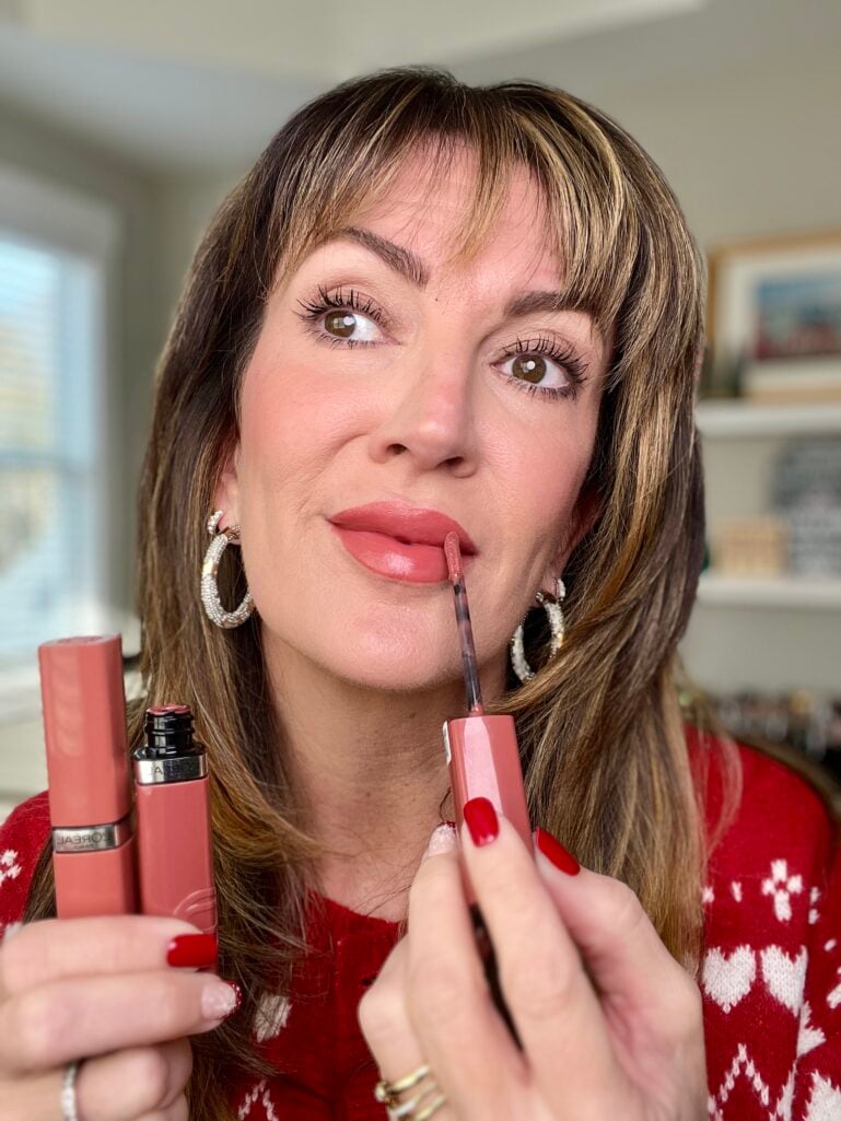 Woman applying L'Oreal Infallible Lacque Resistance liquid lip in Medium Worth It shade with precise applicator