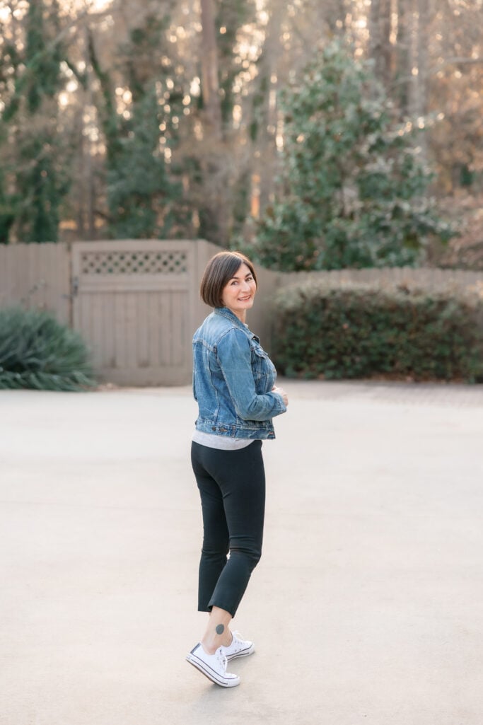 Kelly looking back over shoulder in denim jacket and black ponte pants casual petite outfit