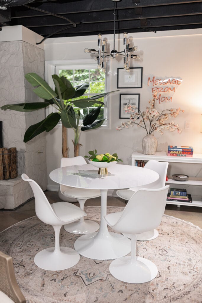 Modern tulip table, chairs, and cane chair on a Kamran Ivory Opal Round Ruggable rug in Beth's basement office and YouTube studio.