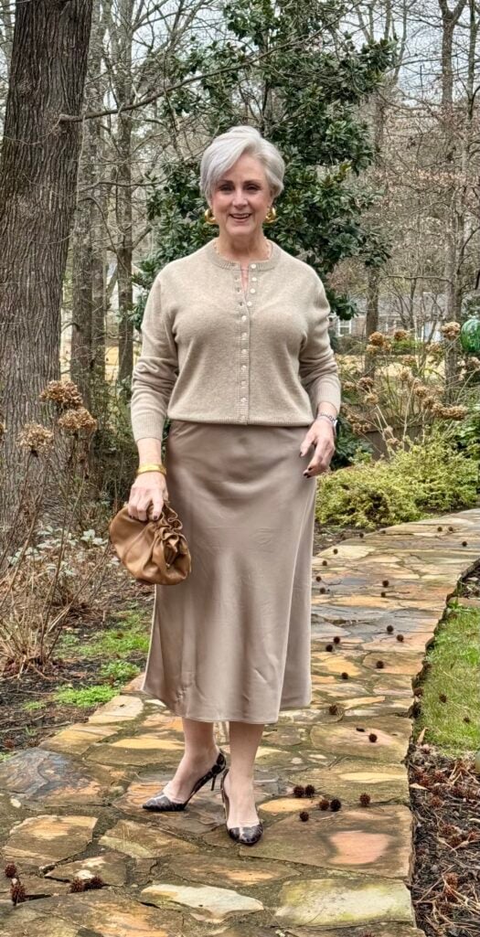 Beth wearing oatmeal cardigan with tonal silk slip skirt and cream heels for a quiet luxury look