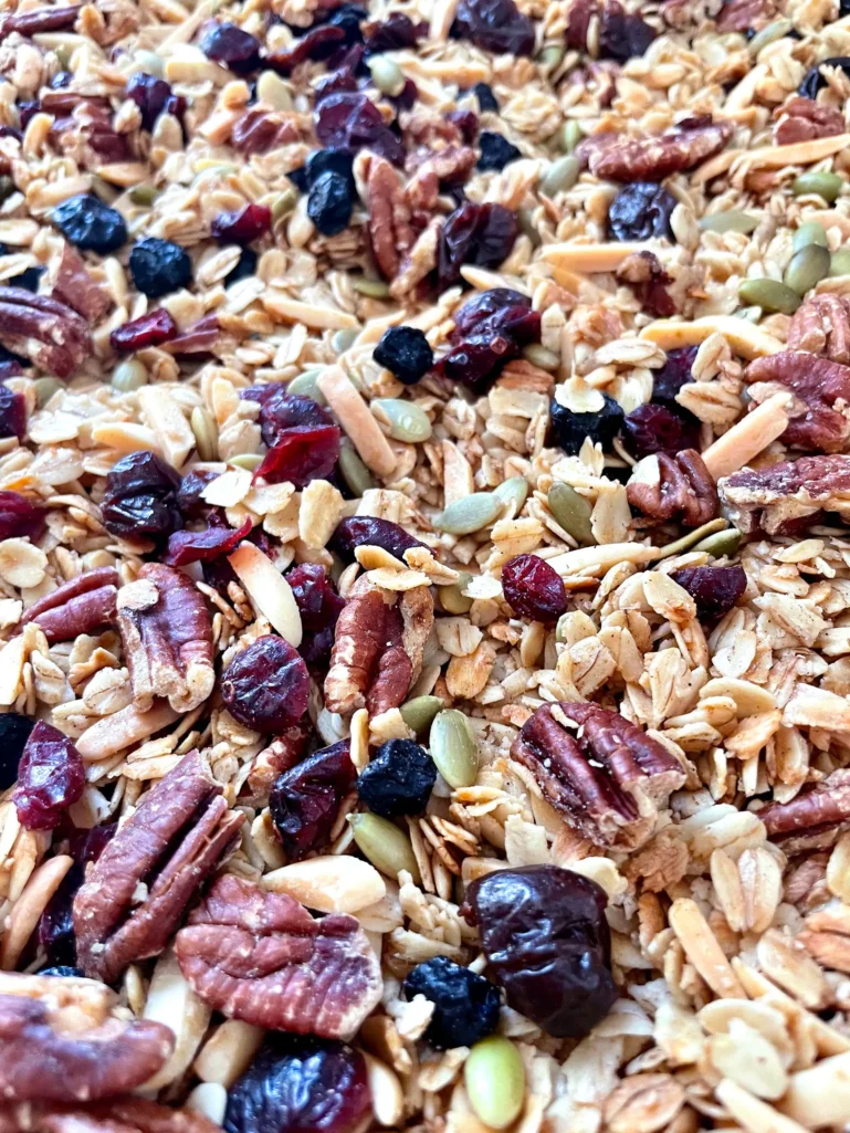 Close-up of finished granola with toasted oats, pecans, almonds, pepitas, and dried fruit