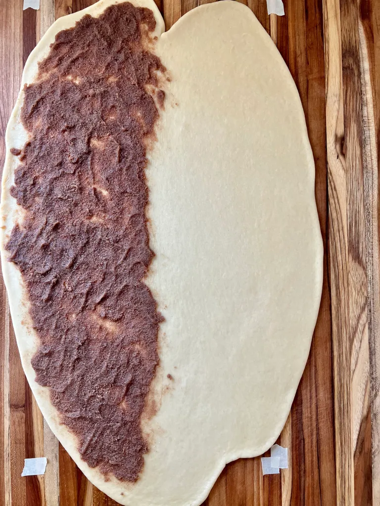 Rolled brioche dough with cinnamon sugar filling spread evenly on one half