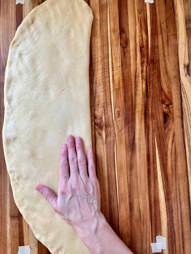 Folding the plain half of the dough over the cinnamon sugar filling and pressing to seal