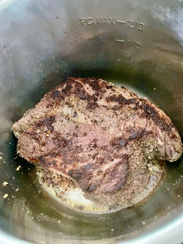 Seared chuck roast with a deep brown crust in the Instant Pot insert