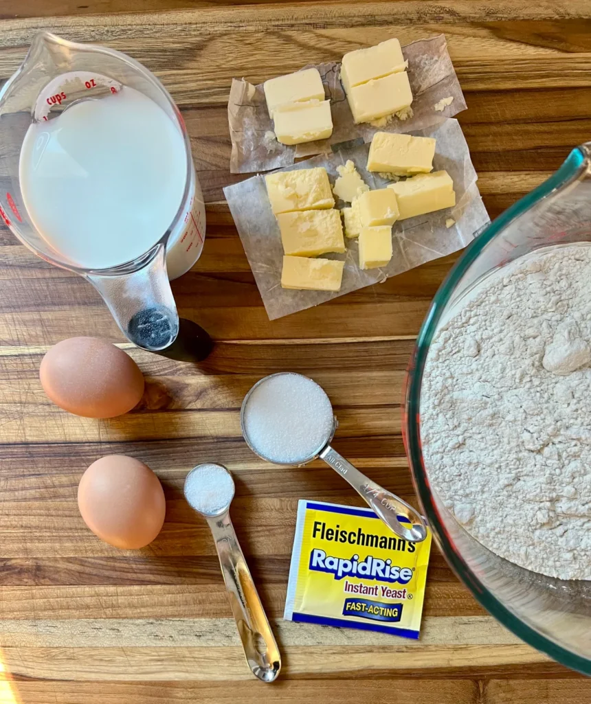 Overhead view of King Cake ingredients: flour, eggs, milk, butter, sugar, salt, and rapid-rise yeast