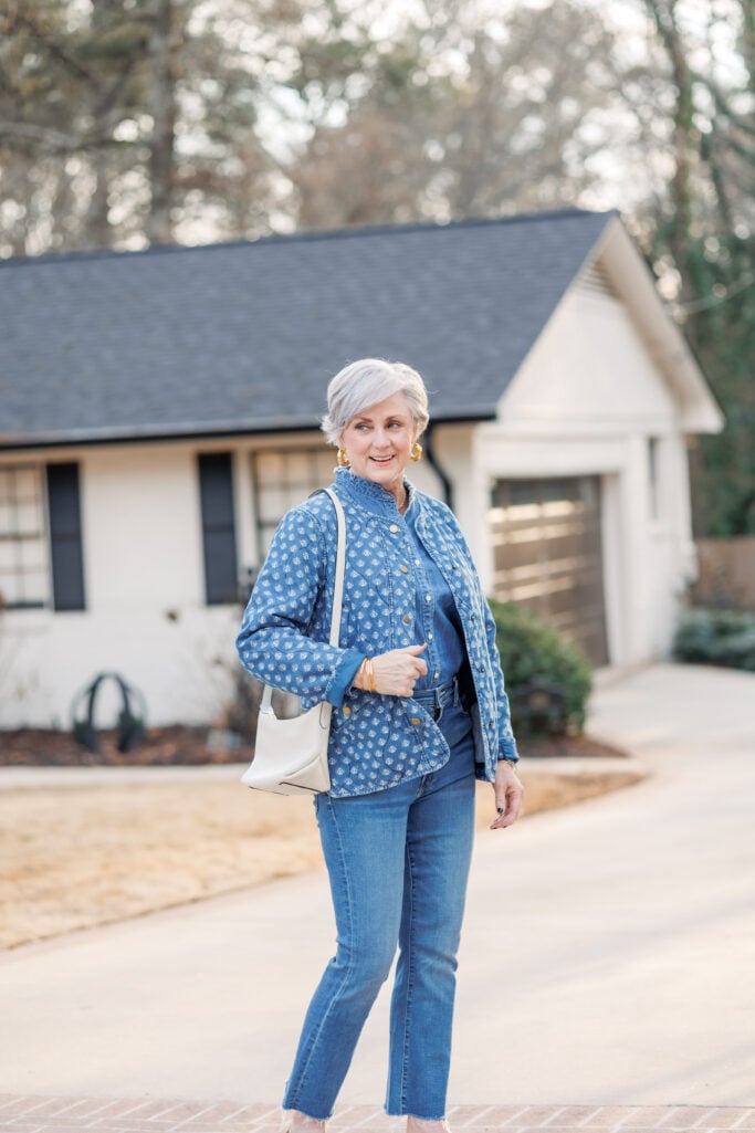 Gold hoop earrings and bangle stack accessorizing denim on denim outfit after 50