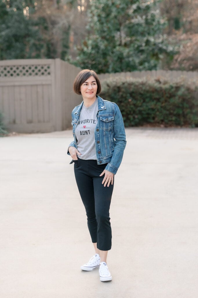 Kelly in a fitted denim jacket over a Favorite Aunt tee with black ponte kick flare pants and white Converse sneakers