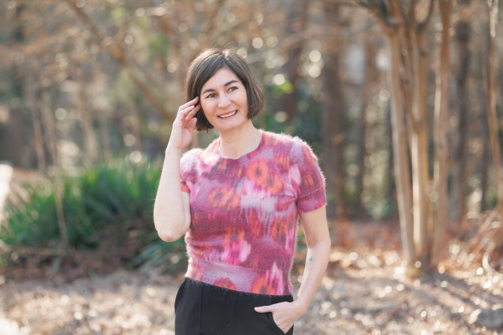 Kelly wearing a pink and coral floral fuzzy sweater tee with black trousers — a pretty transitional print for petites