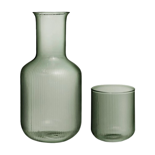 Ribbed glass bedside carafe with matching tumbler in a soft green tint, styled together on a white background as a minimalist bedroom nightstand set.