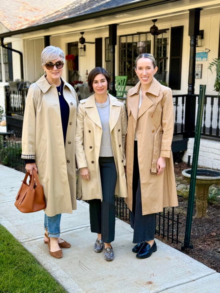 Beth, Kelly, and a friend all wearing classic tan trench coats styled three different ways — proving the trench is a timeless third piece