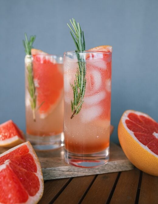 Two Paloma cocktails with wedges of fresh grapefruit