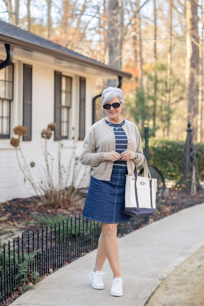 Cardigan with striped tee and denim skirt styled with white sneakers.
