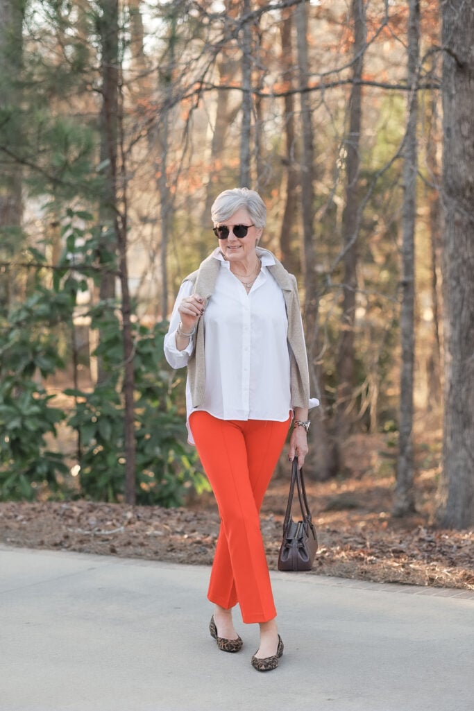 spring style tips for women over 50 color pop orange pants outfit women over 50 orange pants neutral top
