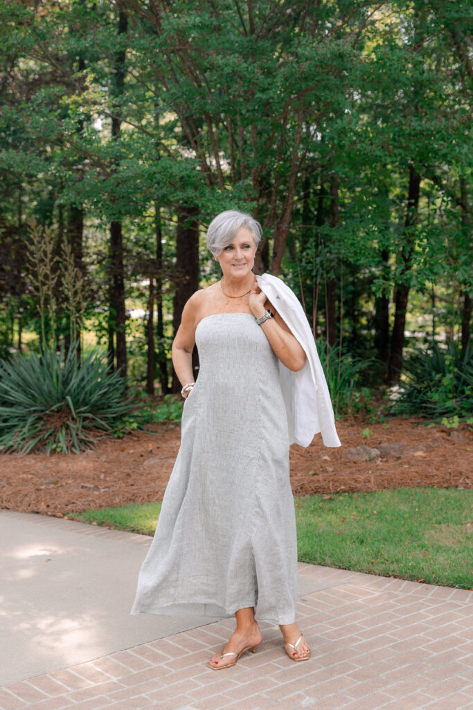 Sage strapless maxi dress + white blazer over shoulder + gold sandals + delicate gold necklace