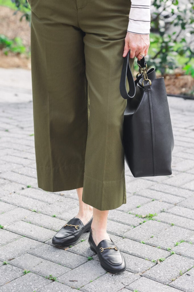 Close-up of green wide-leg cropped pant hem with black Sam Edelman Loraine bit loafers with gold horsebit hardware and black Madewell Essential Bucket Tote — showing the ideal cropped hem and shoe pairing for petite wide-leg styling