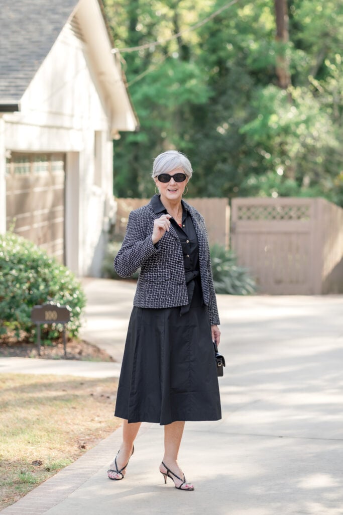Beth wearing a black tweed blazer over a black midi dress with strappy sandals — spring dress styling for women over 50