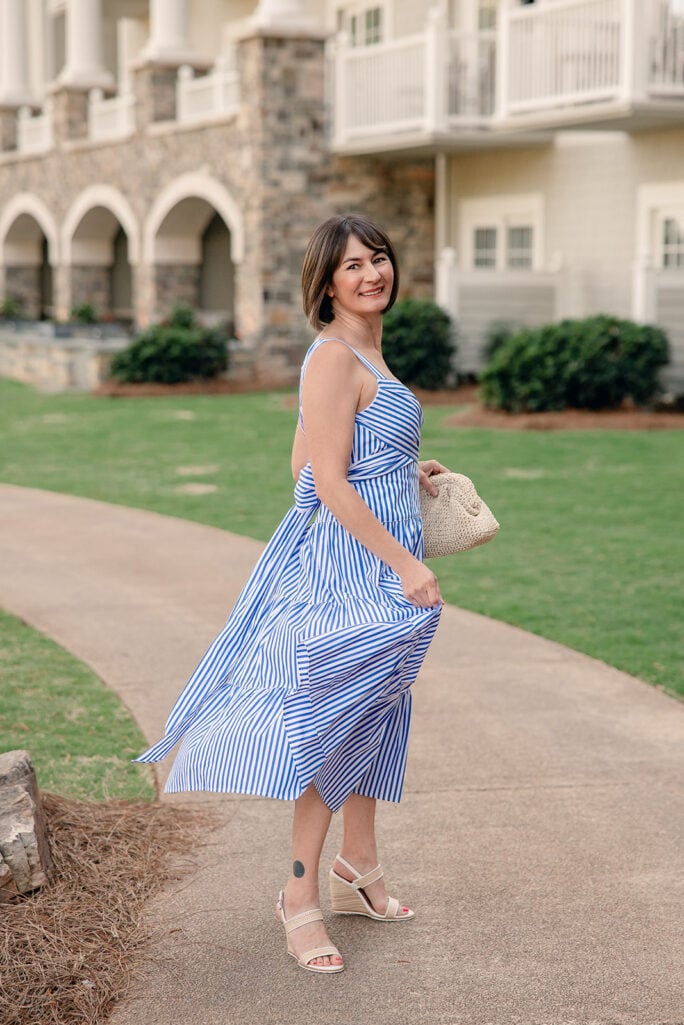 Kelly in blue and white striped tiered dress with skirt in motion, showing volume and movement of tiered cotton midi length — petite tiered dress summer