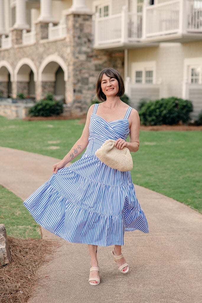 Kelly in blue and white striped tiered dress with skirt in motion, showing volume and movement of tiered cotton midi length — petite tiered dress summer