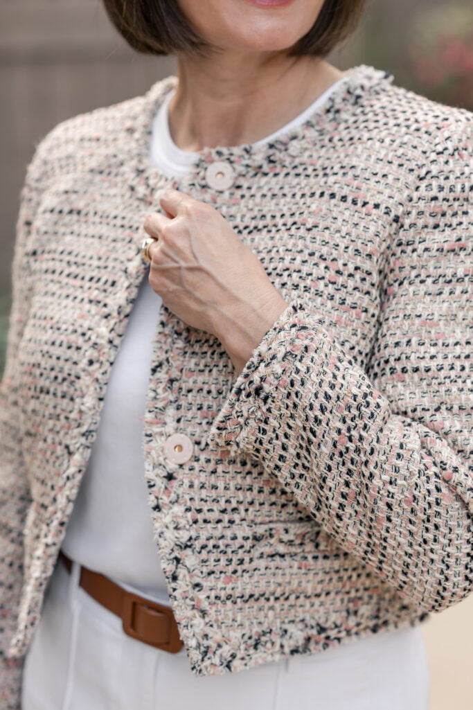 Close-up of Lady Jacket in Italian Textured Tweed showing cream, black, and blush woven detail with fringe trim and button closure — petite investment jacket