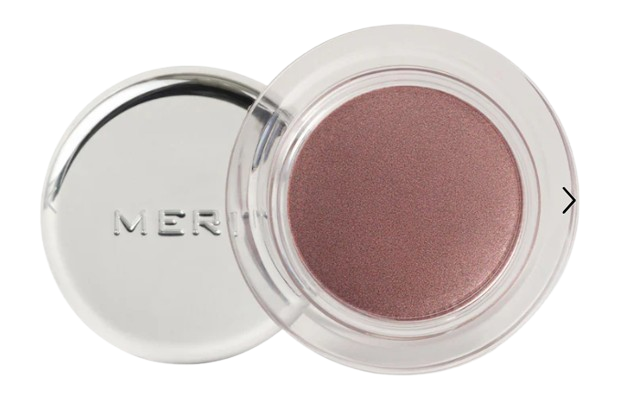 Open cream eyeshadow pot in soft plum shade with a smooth, shimmery finish, shown in a clear compact with lid beside it.