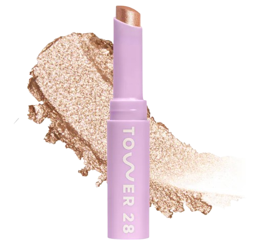 Shimmer eyeshadow stick in golden amber shade with creamy texture, shown in a lavender tube with swatch of metallic gold shimmer behind it.