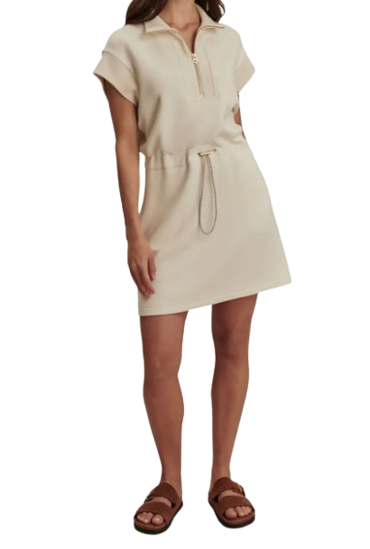 Varley Avaya Half-Zip Mini Dress in beige featuring short dolman sleeves, stand collar with half-zip neckline, adjustable drawstring waist, and relaxed silhouette styled with flat sandals.