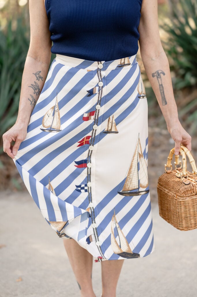 Close-up of Ralph Lauren Button Front Crepe Skirt showing diagonal navy and white stripe pattern with sailboat print detail and white button placket — petite-friendly nautical midi skirt