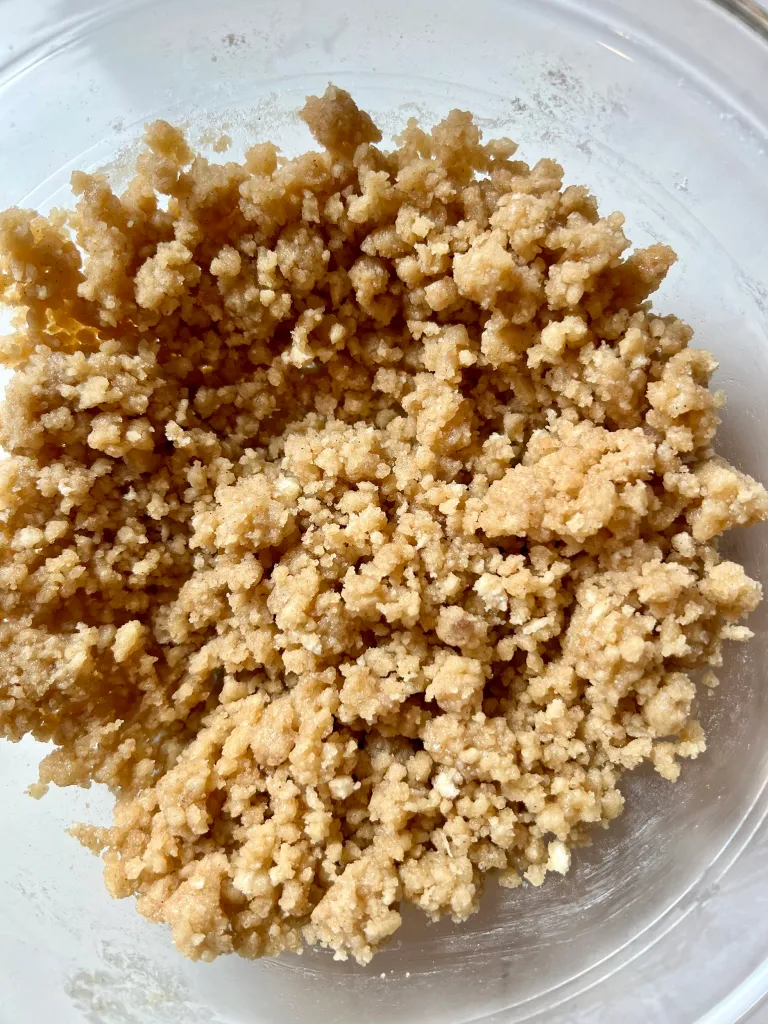 Finished buttery panko crisp topping in a glass bowl, showing a clumpy, sandy texture ready to refrigerate