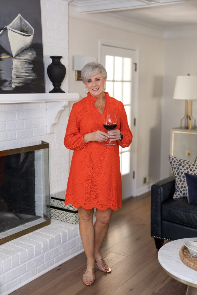 Burnt orange eyelet shift dress with ruffled neckline and gold strappy sandals