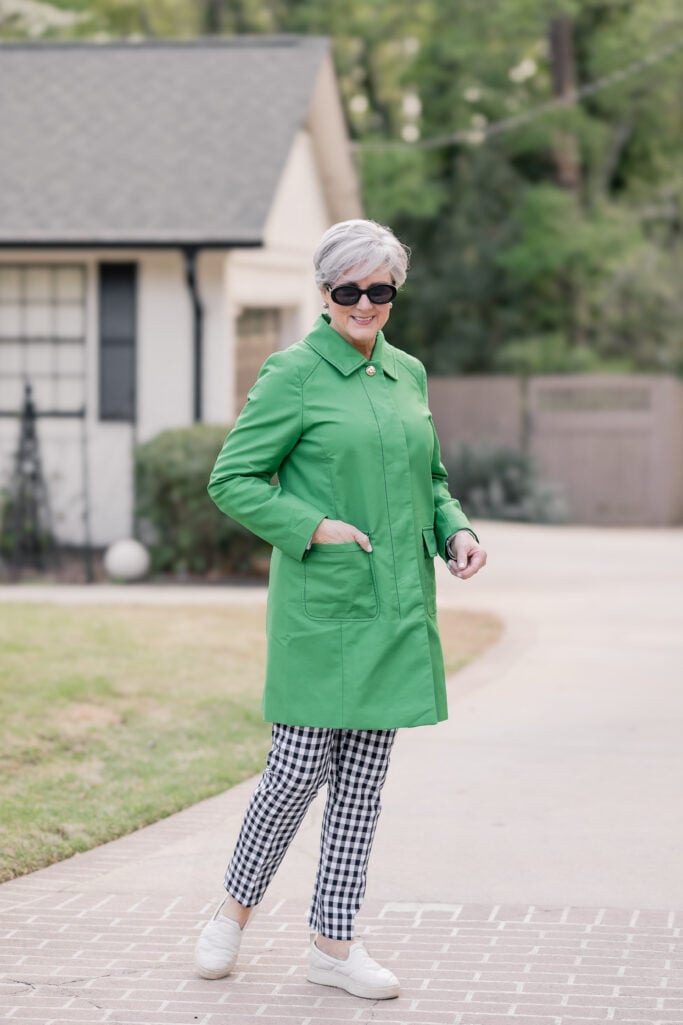 Kelly green topcoat styled over black-and-white gingham pants with white slip-on sneakers