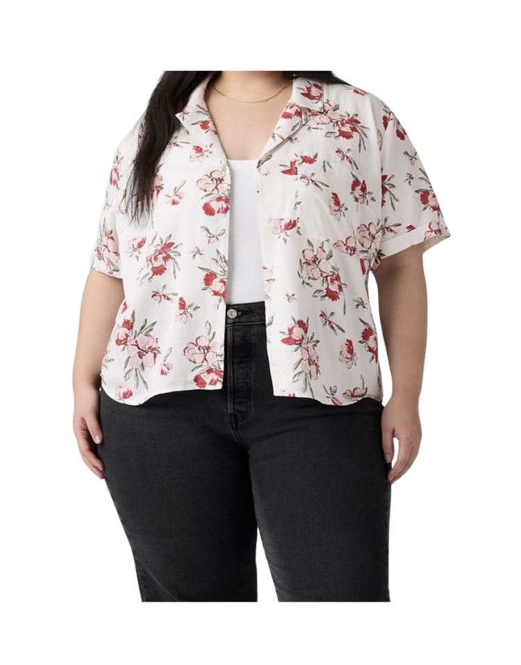 White short-sleeve cropped camp collar button-front shirt in a red, pink, and green floral print, styled open over a white tank top with black jeans — a lightweight cotton camp shirt for layering in summer.