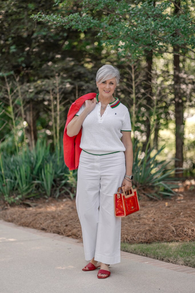 Americana fashion trend over 50 with red linen blazer, striped polo, white wide-leg pants, red sandals and red handbag