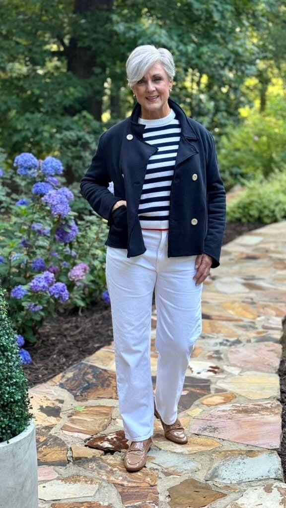 Navy French terry jacket, mariner stripe crewneck, and dark jeans for a classic nautical airport-to-lunch look