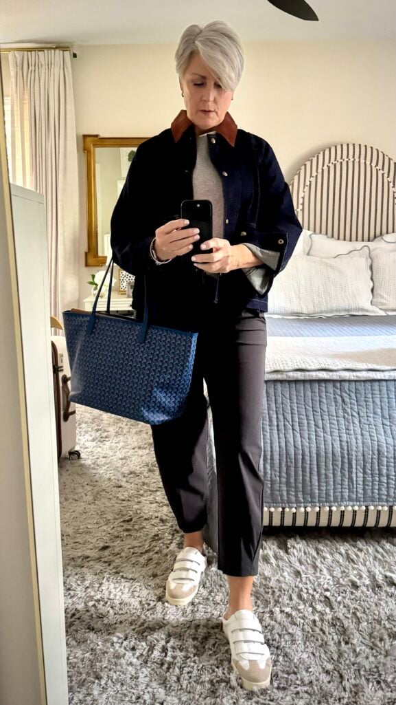 Comfortable weekend travel outfit for women over 50 — denim jacket, cashmere tee, slim pants, and slip-on sneakers.